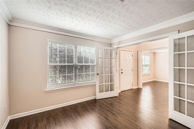 Spare room featuring french doors, a textured ceil