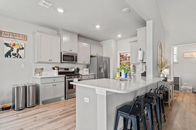 Kitchen with tasteful backsplash, appliances with