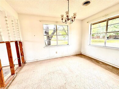Spare room with a notable chandelier and a textured ceiling