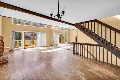 Unfurnished living room with beamed ceiling, stair
