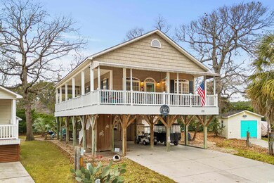 Beach home with a storage unit, a porch, and a car