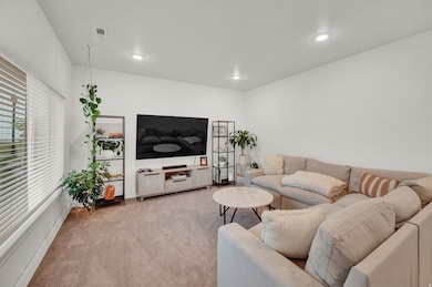 Living area with carpet flooring and recessed lighting