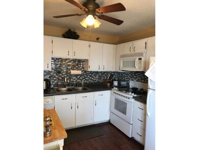Kitchen with tile backsplash & ceiling fan.
