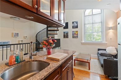 Kitchen featuring a sink, light stone counters, li
