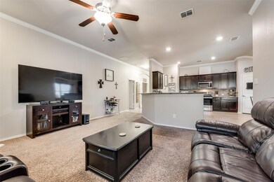 Carpeted living room with crown molding and ceiling fan