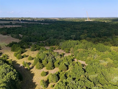 Aerial view of property's location featuring a heavily wooded area