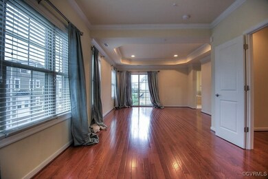 Unfurnished room with wood finished floors, baseboards, a smoke detector, ornamental molding, and a tray ceiling