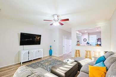 Living room with wood finished floors and ceiling fan