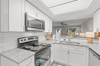 Kitchen featuring kitchen peninsula, sink, white c