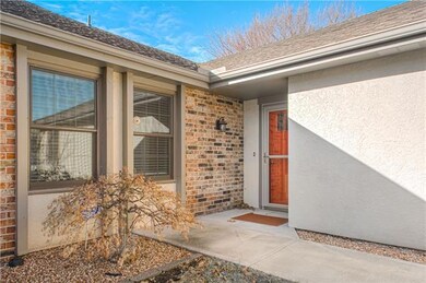 Covered entry with an eye-popping orange door says
