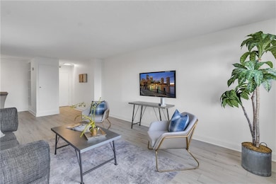 Living area with light wood-style floors and baseboards
