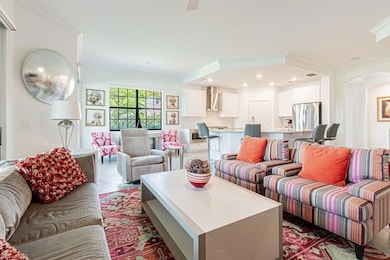 Living area with arched walkways, crown molding, recessed lighting, and tile patterned flooring