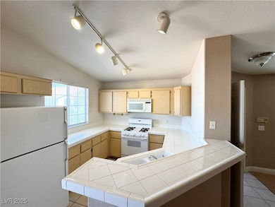 Kitchen with white appliances, light brown cabinet