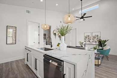 Kitchen featuring dishwasher, a sink, baseboards,