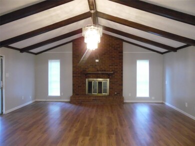 Unfurnished living room with a brick fireplace, a 
