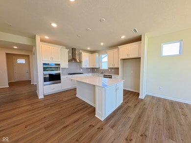kitchen with tasteful backsplash, white cabinets, a center island, and recessed lighting