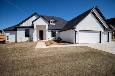 View of front of home with a front yard and a gara