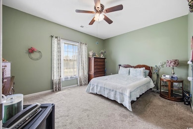 Carpeted bedroom featuring baseboards and a ceiling fan