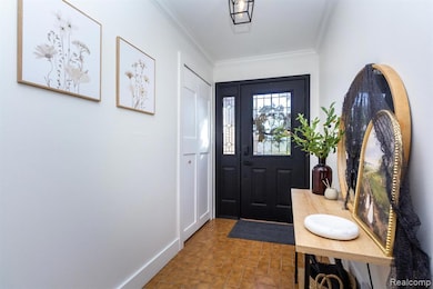 Foyer featuring crown molding and baseboards