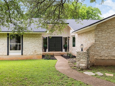 View of exterior entry with roof with shingles, a