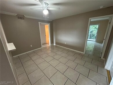 Tiled spare room featuring crown molding and ceili