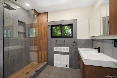 Bathroom featuring vanity, walk in shower, and recessed lighting