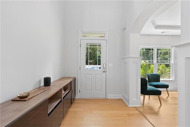 Entrance foyer with light wood-style flooring and arched walkways