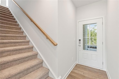 Doorway featuring light wood-style floors, baseboa