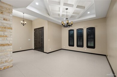 Spare room featuring light tile floors, beam ceiling, coffered ceiling, and a notable chandelier