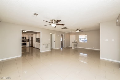 Unfurnished living room featuring ceiling fan, a t