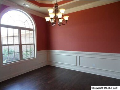 Dining room has 10 foot ceilings, half arch window, hardwood floors, chair rail with shadow box trim. crown molding. Picture from similar home.