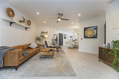 Living room featuring crown molding, light wood-style floors, ceiling fan, and recessed lighting