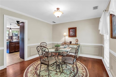 Dining space featuring a wainscoted wall, visible 
