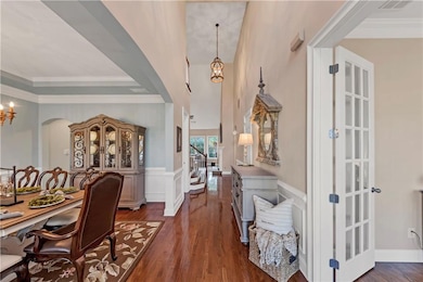 Foyer featuring crown molding, stairs, dark wood-t
