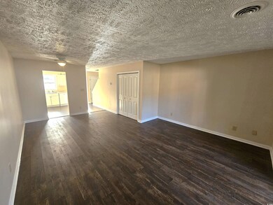 Unfurnished room featuring ceiling fan, dark hardw