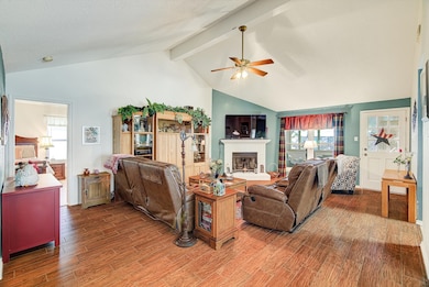 Living Room (Angle 2) – Another view of the living space showing the brick fireplace with mantle, large window for natural light, and room for multiple furniture layouts.
