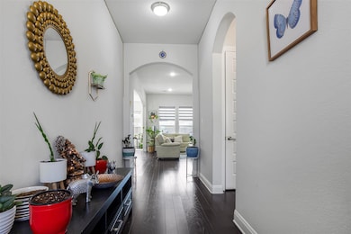 Hall with arched walkways, dark wood finished flo