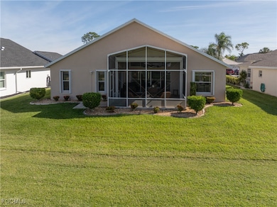Rear view of house with stucco siding, a yard, and a sunroom