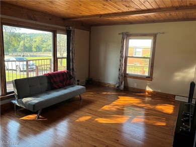 Sitting room featuring a wooden ceiling with exposed beams and hardwood / wood-style flooring