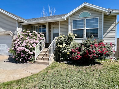 Doorway to property featuring a yard, a porch, roof with shingles, and a garage