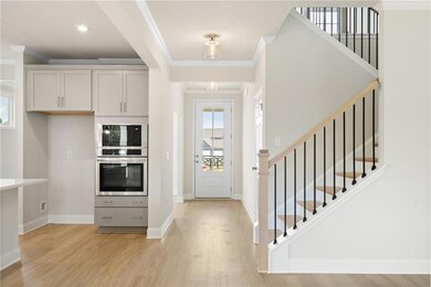 Foyer entrance featuring stairs, light wood-type flooring, crown molding, and baseboards