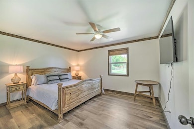 Bedroom featuring ornamental molding, light wood-t