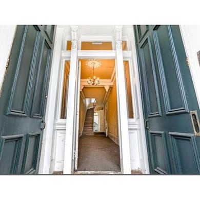 Double door entry and the original grand staircase and entry hall with 13’ ceilings. Private entry to unit #1 to the right. Staircase leads to 2nd floor units.