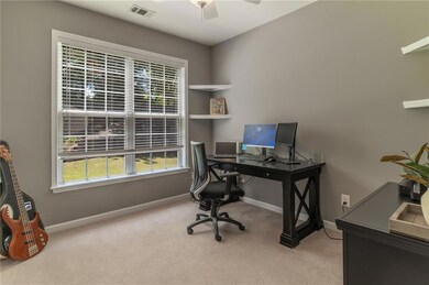 Office with carpet flooring, ceiling fan, and baseboards