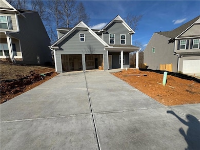 View of front of home with a porch, concrete driveway, and a garage