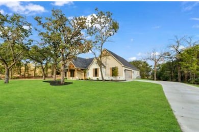 View of front of house with a front yard, driveway, and an attached garage