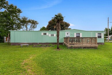 Rear view of property featuring a deck and a lawn