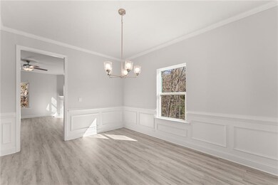 Stock PhotoEmpty room with a wainscoted wall, a chandelier, light wood-type flooring, ornamental molding, and a decorative wall