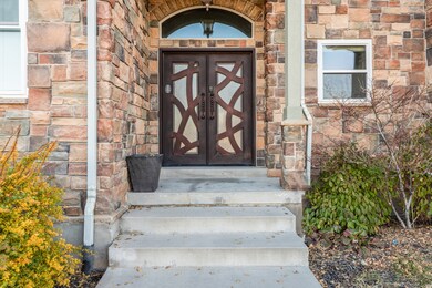 View of exterior entry with stone siding and french doors
