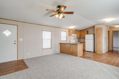 Kitchen with stove, ceiling fan, light brown cabin